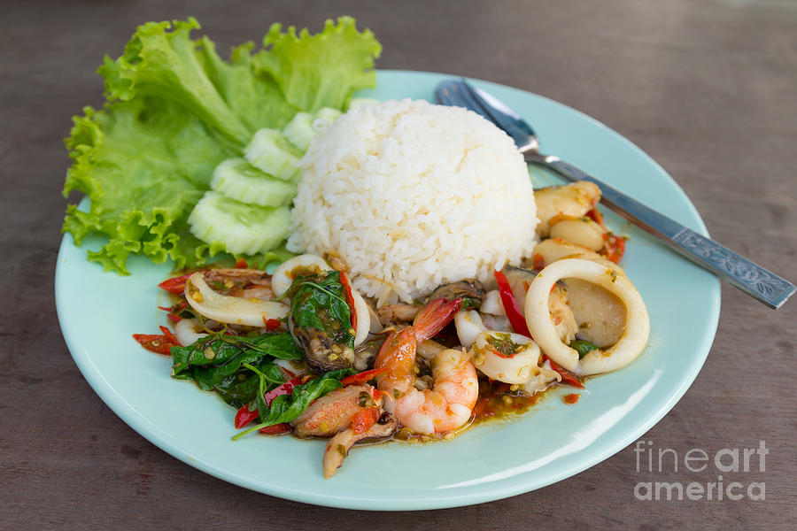 fried seafood with basil leaves on Steamed rice. Photograph by Tosporn Preede