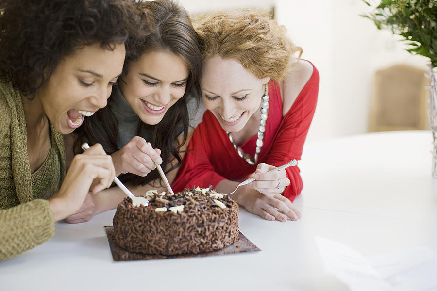 Friends eating chocolate cake Photograph by Paul Bradbury