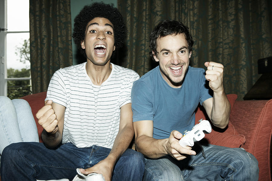 Friends playing video game Photograph by John Howard