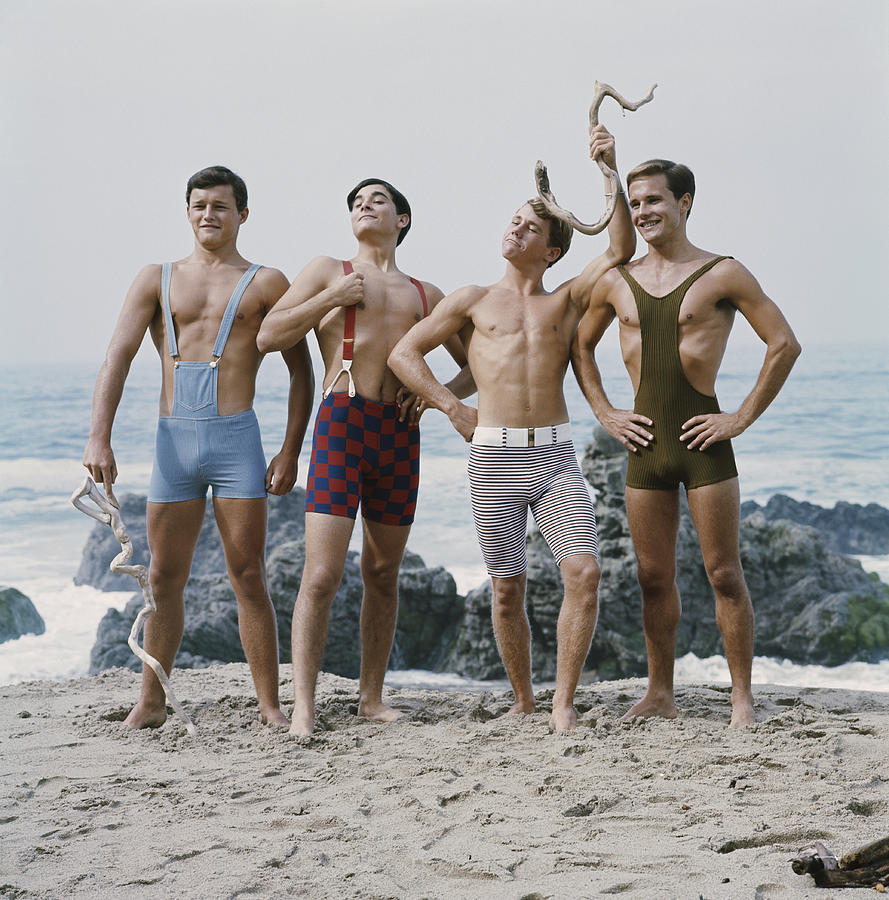 Friends standing on beach, smiling Photograph by Tom Kelley Archive
