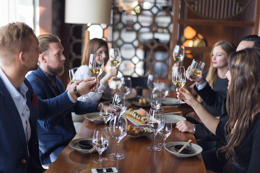 Friends toasting wine in restaurant Photograph by Zoranm