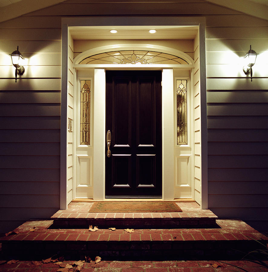 Front door of house with lights at night Photograph by Siri Stafford