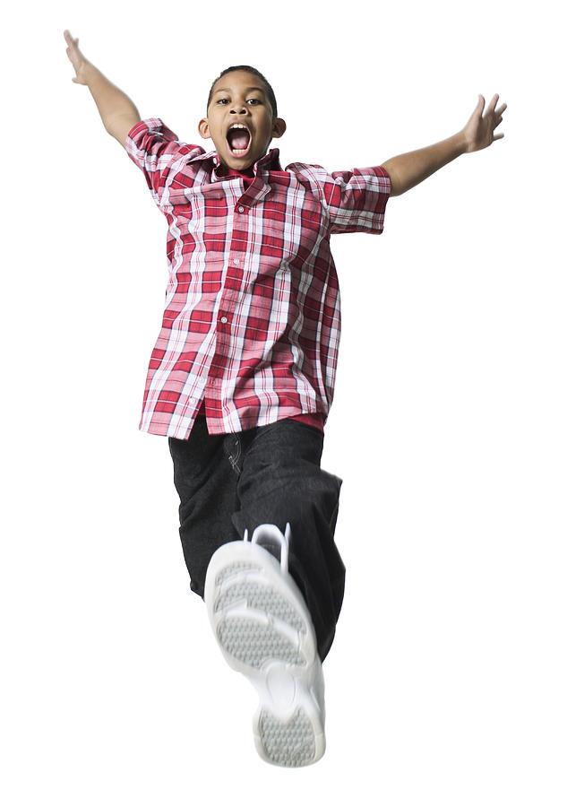 Full Body Shot Of A Male Child As He Runs And Jumps Through The Air Photograph by Photodisc