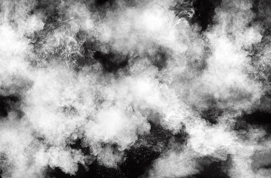Full frame of forms and textures of an explosion of powder and smoke of color white on a black background. Photograph by Jose A. Bernat Bacete