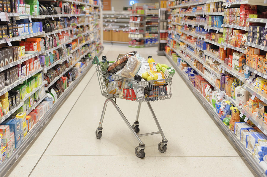Full shopping cart in supermarket aisle Photograph by Jacobs Stock Photography Ltd