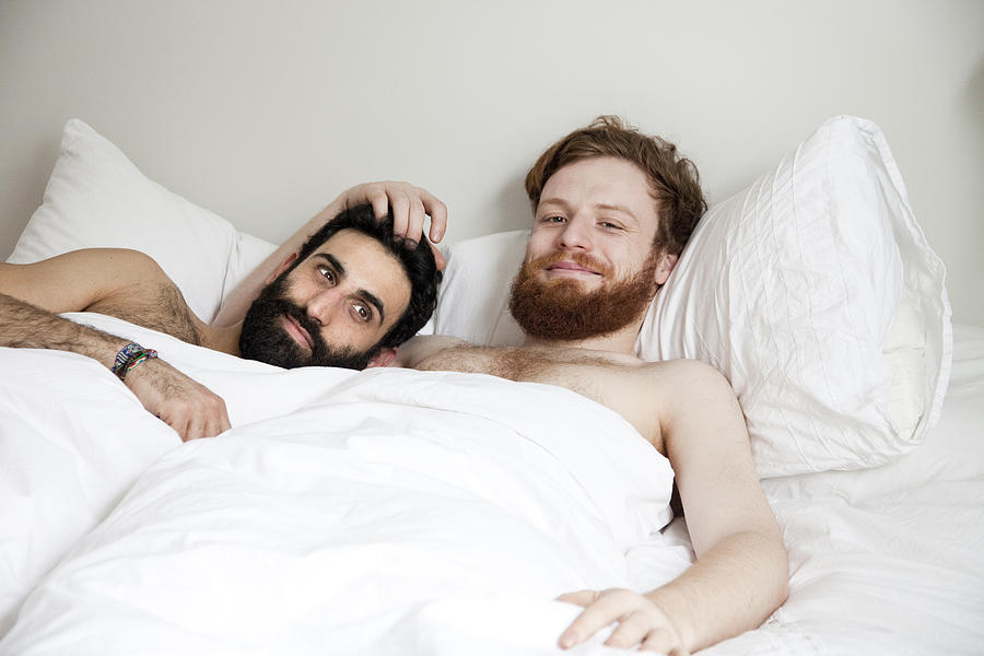 Gay couple cuddling in bed Photograph by Claudia Burlotti