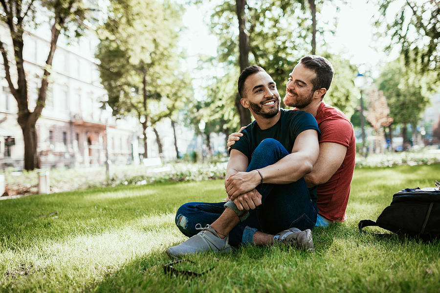 Gay couple - Latino and European millennial men - enjoying in park in summer Photograph by Drazen_
