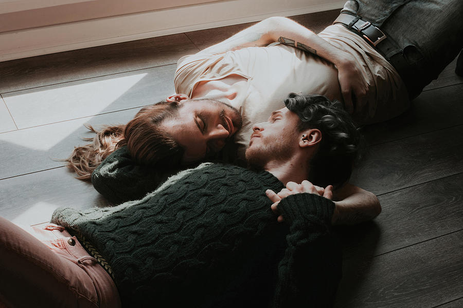 Gay couple lying on floor holding one another. Photograph by Mark Liddell Gay couple lying on floor holding one another. Photograph by Mark Liddell