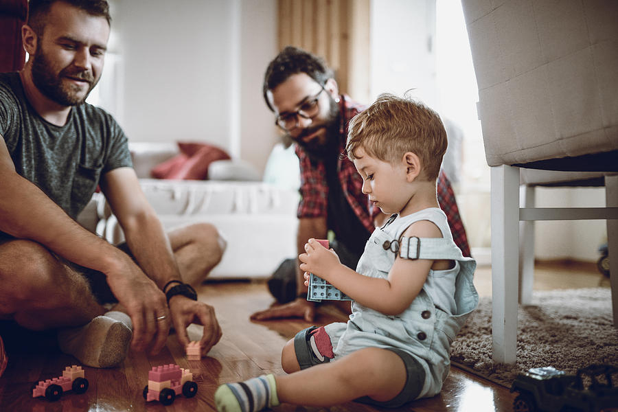 Gay Couple Playing With Adopted Baby Son And His Toys Photograph by AleksandarGeorgiev