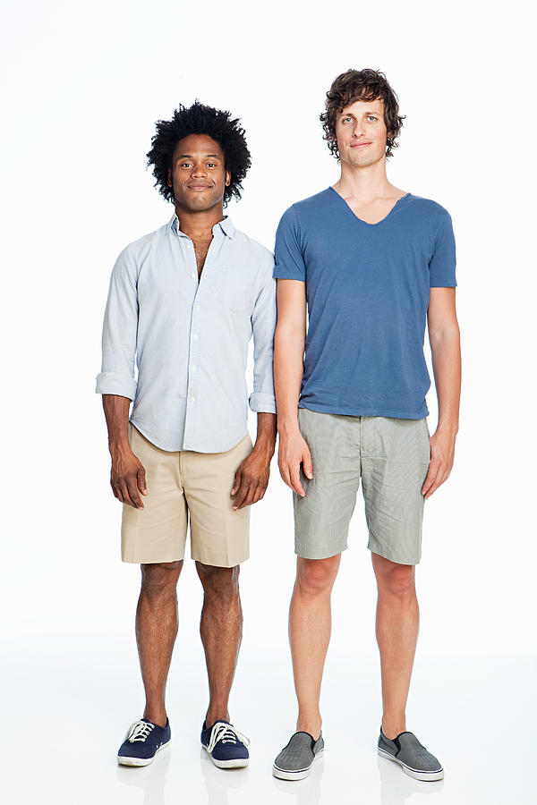 Gay couple standing against white background Photograph by Image Source