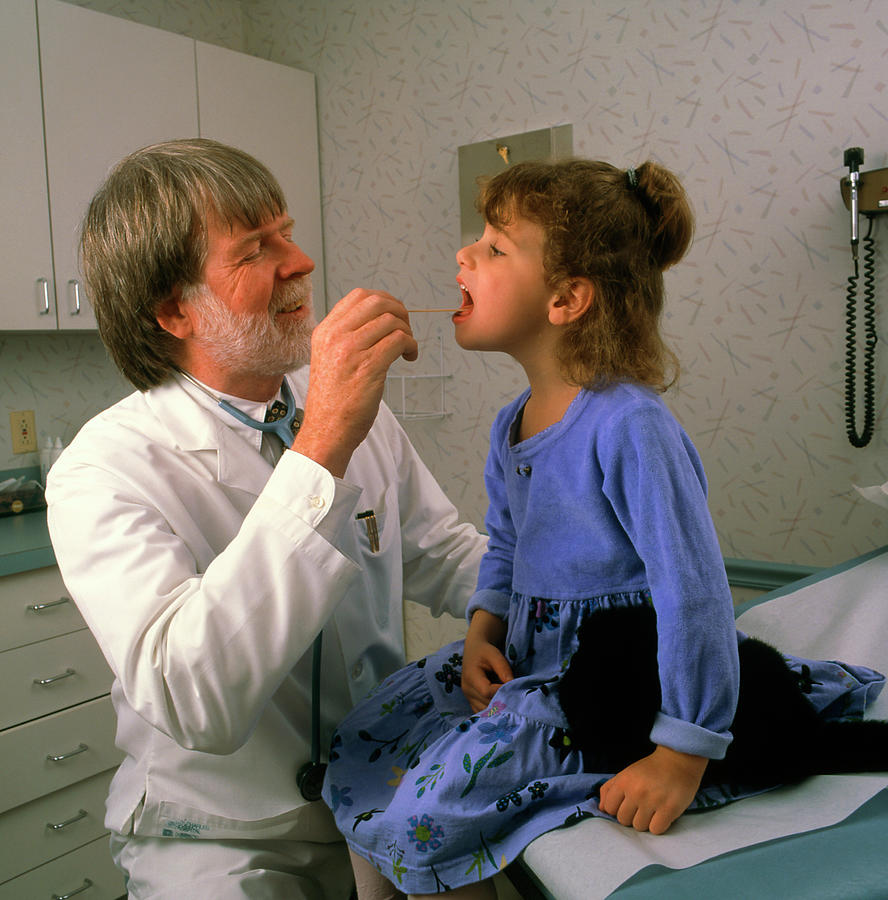 General Practice Doctor Examines A Girls Throat Photograph by Stevie Grand/science Photo Library