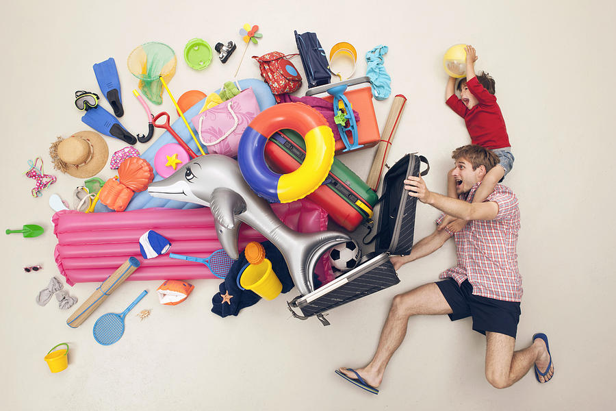 Germany, Artificial scene with man opening baggage full of beach toys Photograph by Westend61