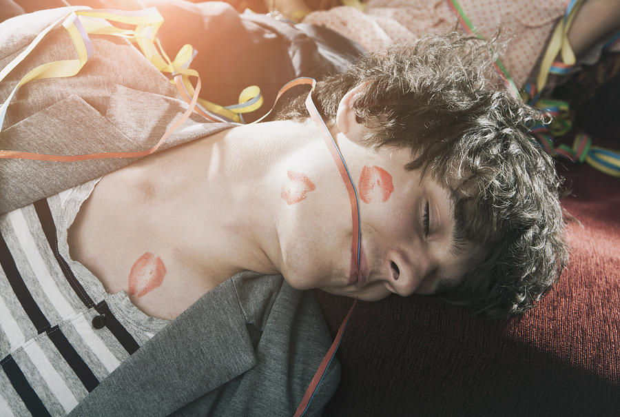 Germany, Berlin, Close up of young man with lipstick kiss sleeping after party Photograph by Westend61
