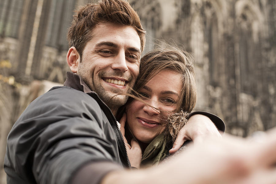 Germany, Cologne, young couple taking selfie in front of Cologne Cathedral Photograph by Westend61