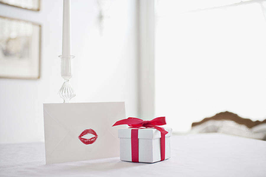 Gift box with ribbon and card with lipstick kiss on desk Photograph by Robert Daly