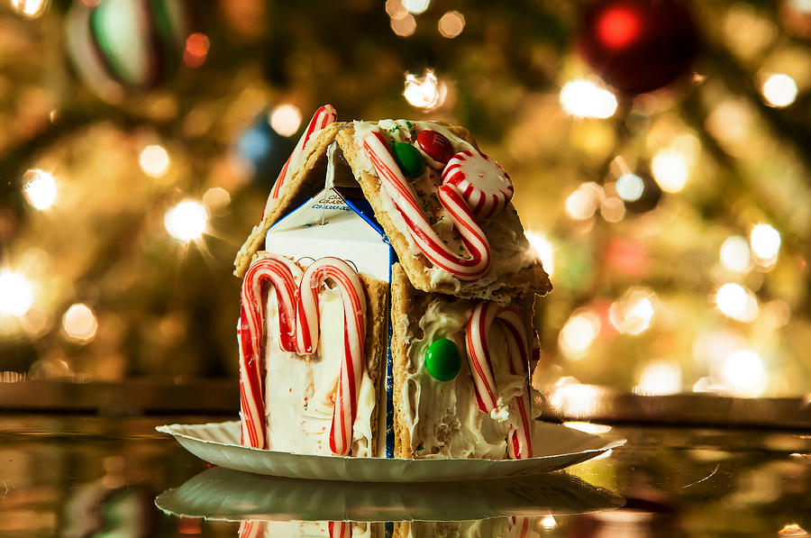 Gingerbread house against a background of christmas tree lights Photograph by Alex Grichenko