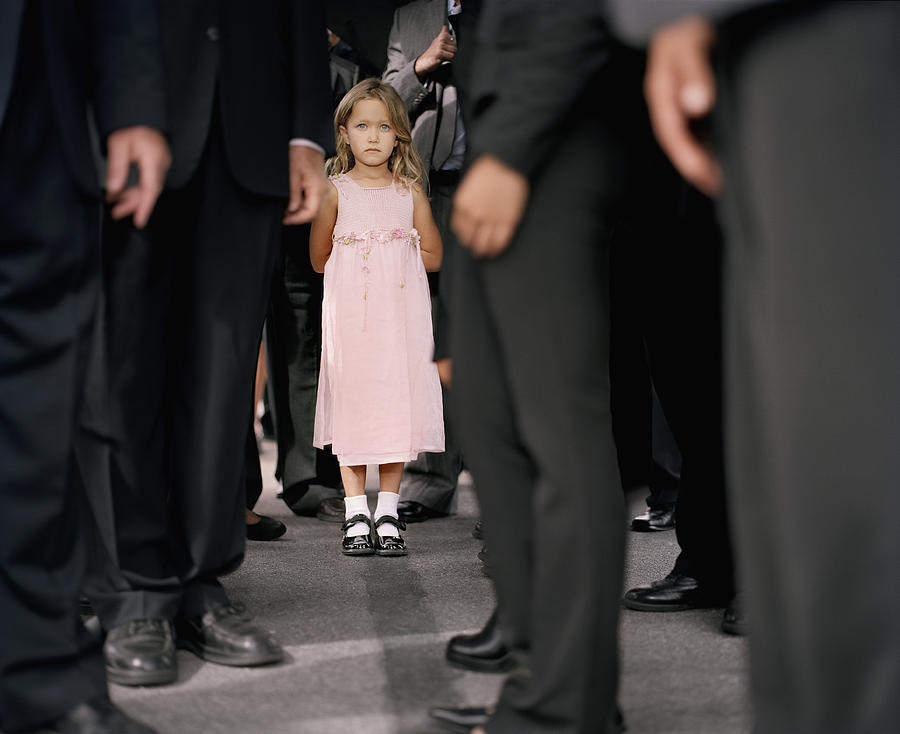 Girl (4-6) standing in crowd of businesspeople (focus on girl) Photograph by Matthias Clamer