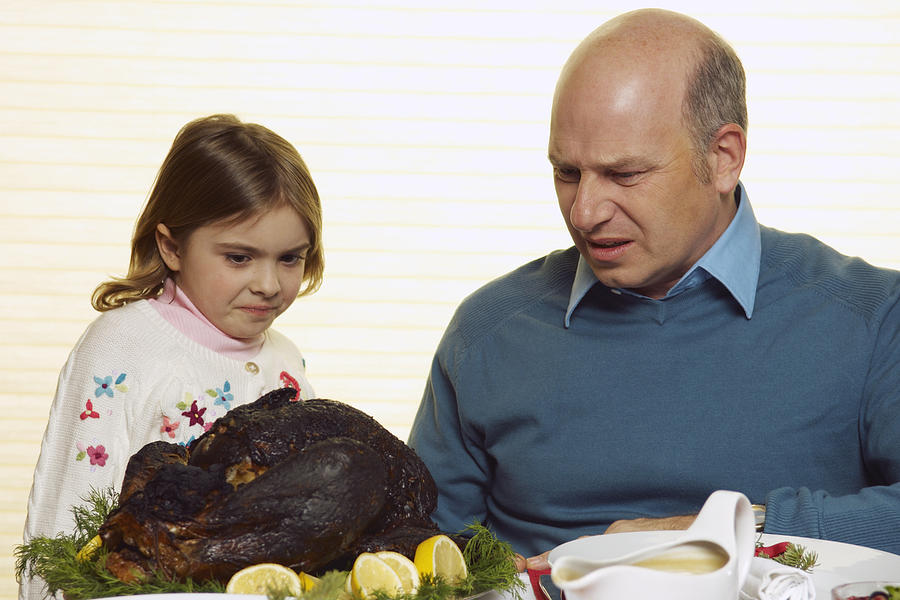 Girl and man looking at burnt turkey Photograph by Beau Lark/Corbis/VCG