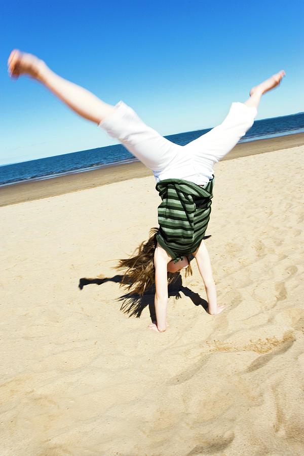Girl Doing A Cartwheel Photograph by Gustoimages/science Photo Library