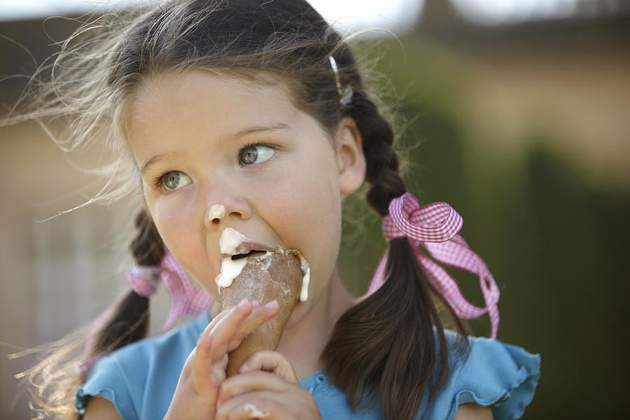 Girl eating messy ice cream cone Photograph by Adam Gault