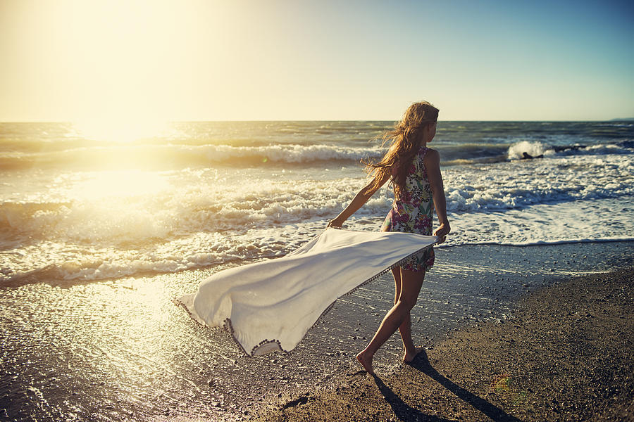 Girl enjoying sunset on a windy beach Photograph by Imgorthand