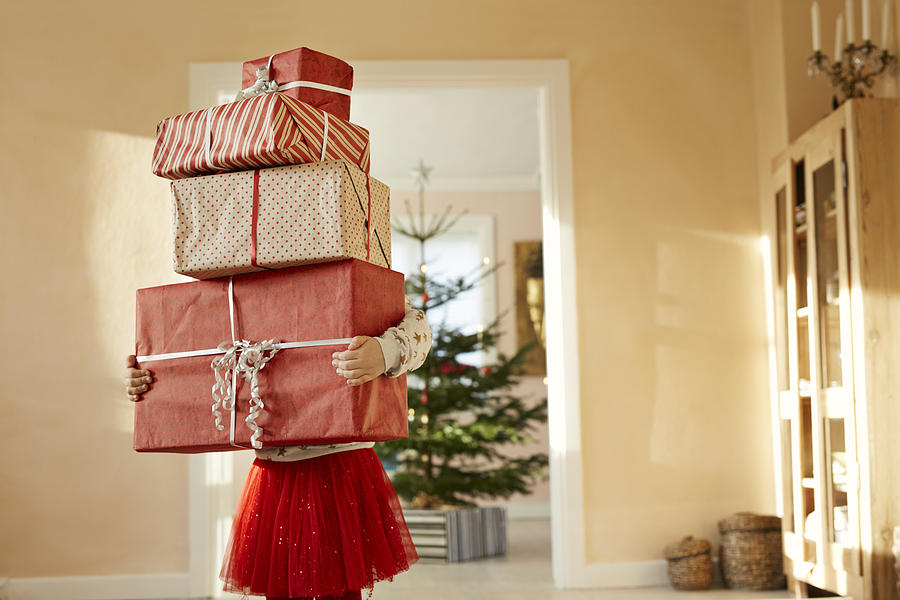 Girl holding tall stack of christmas presents Photograph by Klaus Vedfelt