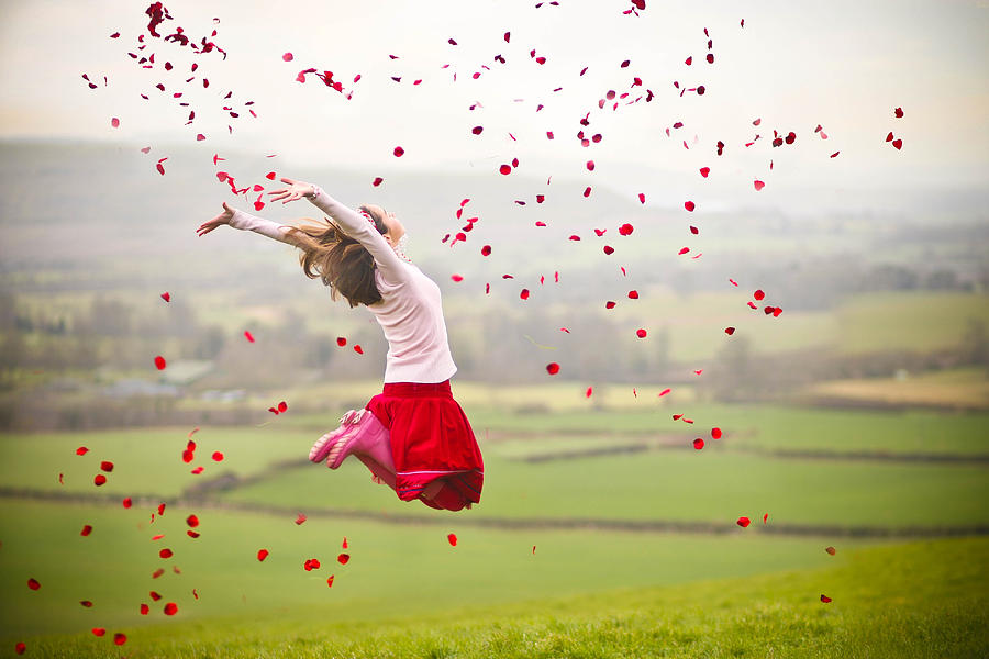 Girl jumping with rose petals in air Photograph by Olivia Bell Photography