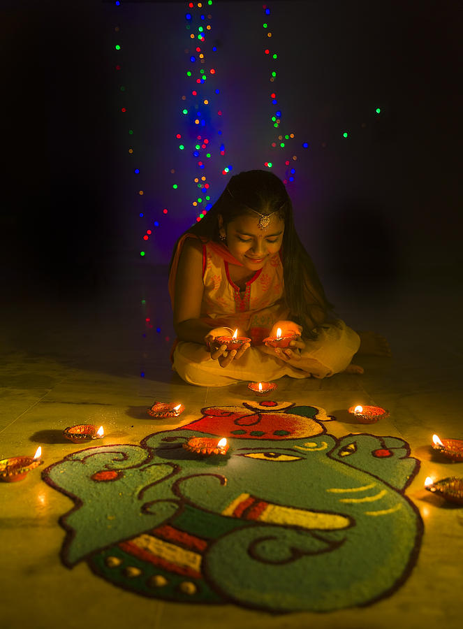 Girl making Rangoli and decorating with oil lamps for Diwali Photograph by SoumenNath