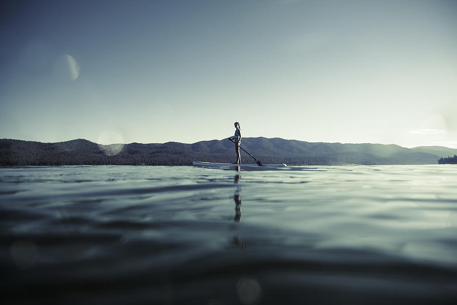 Girl on paddle board on lake Photograph by Dana Neibert