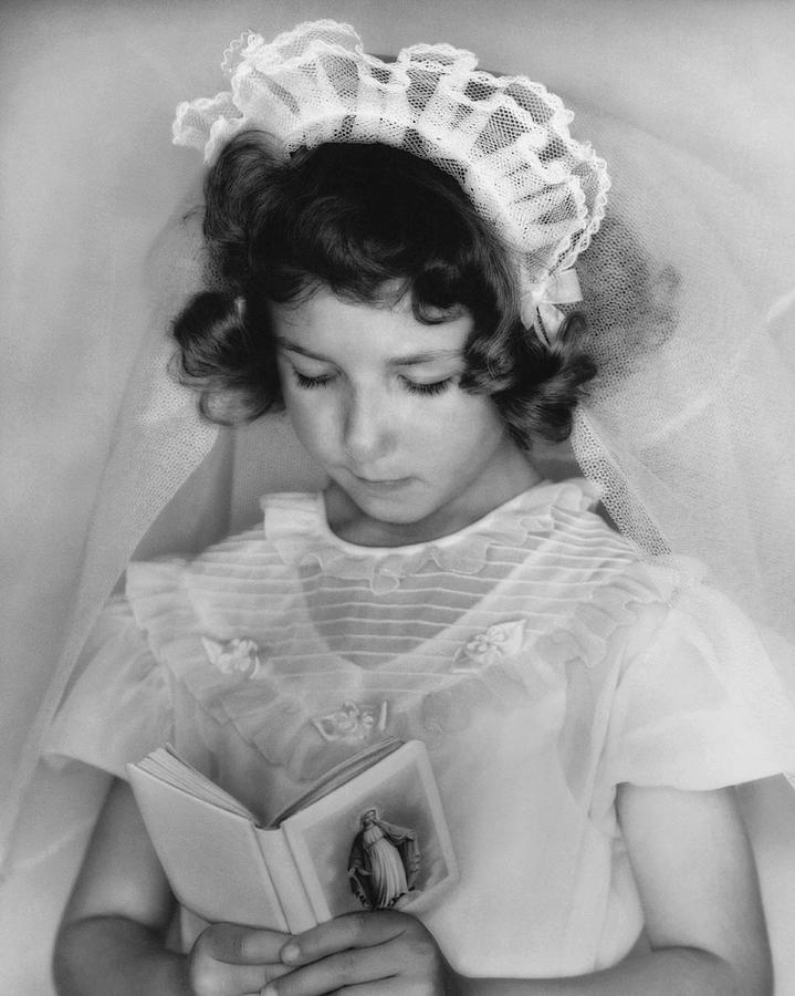 Black And White Photograph - Girl Reading A Prayer Book by Underwood Archives
