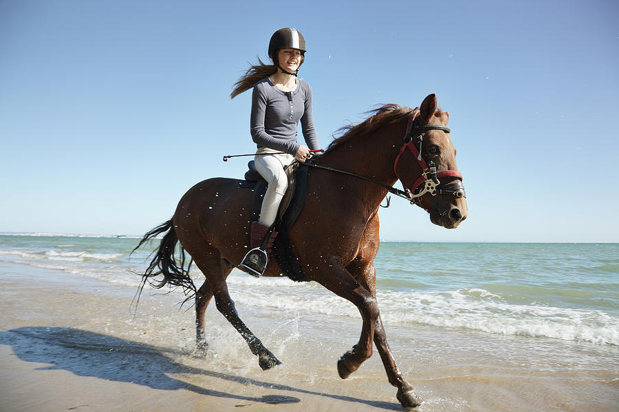 Girl riding horse on beach Photograph by Anthony Lee