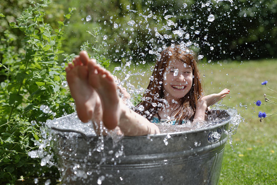 Girl splashing in a zinc tub Photograph by Westend61
