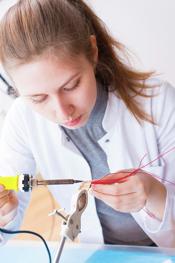Indoors Photograph - Girl Using Soldering Iron by Wladimir Bulgar/science Photo Library