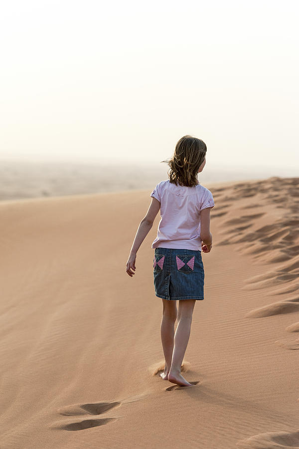 Girl walking in desert, rear view Photograph by PhotoAlto/Thierry Foulon
