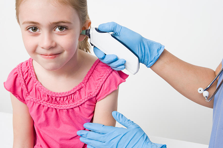 Girl with thermometer in ear Photograph by Image Source