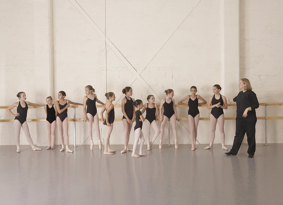 Girls (9-13) in ballet class with ballet instructor Photograph by David Fischer