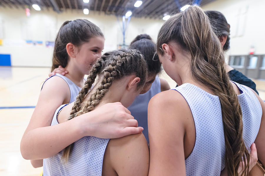 Girls basketball coach leads a pre-game huddle Photograph by FatCamera