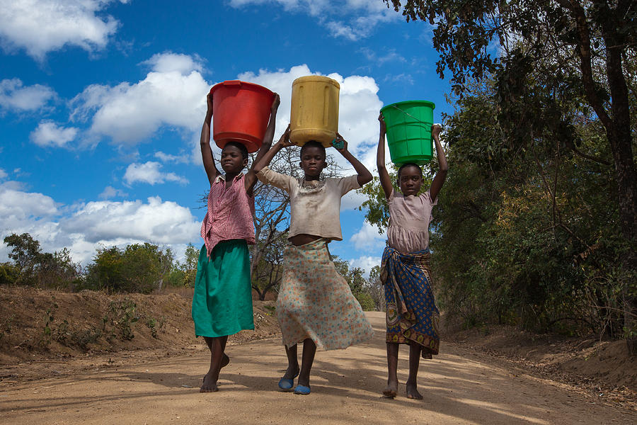 Girls carrying water buckets at a borehole in Malawi Photograph by Guido Dingemans, De Eindredactie