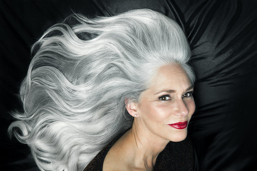 Glamorous portrait of a woman with long gray hair. Photograph by Andreas Kuehn