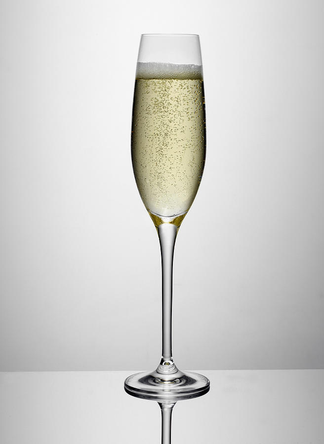 Glass of champagne indoors Photograph by Simon Murrell