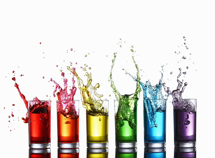 Glasses of colorful liquid splashing Photograph by Maren Caruso