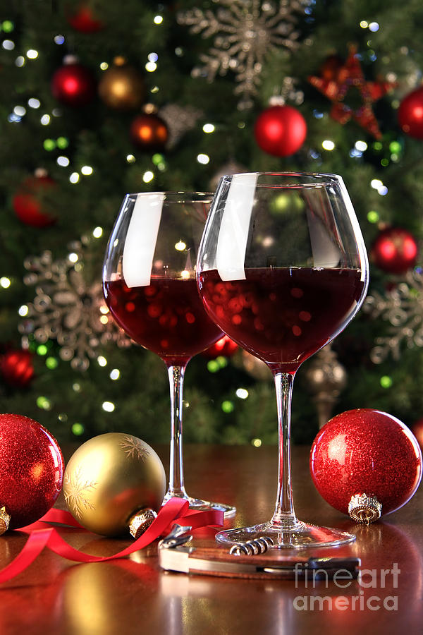 Glasses of red wine in front of Christmas tree Photograph by Sandra Cunningham