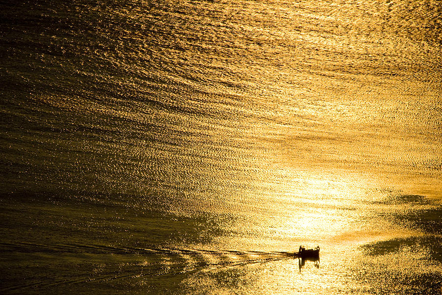 Golden sea with boat at sunset Photograph by Raimond Klavins
