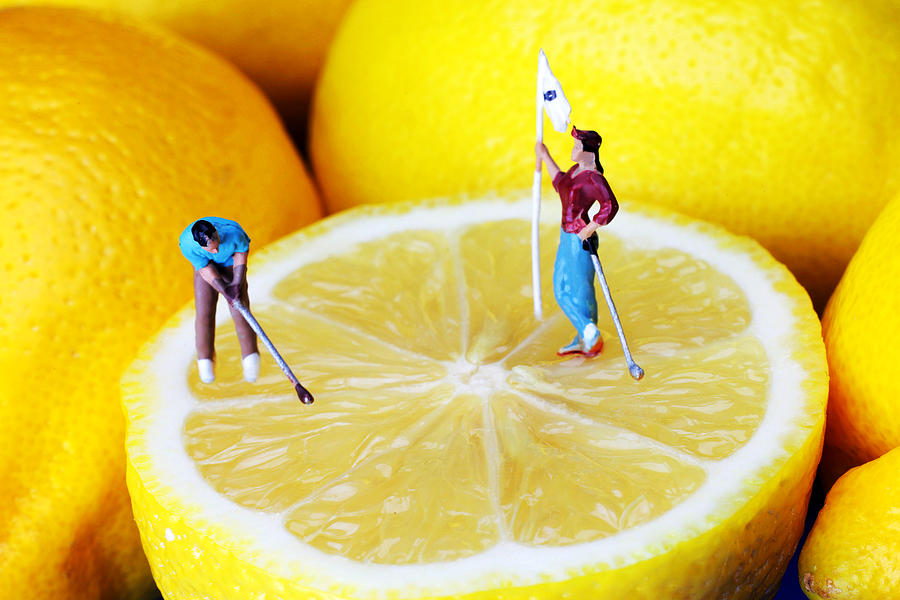 Golf game on lemons little people on food Photograph by Paul Ge