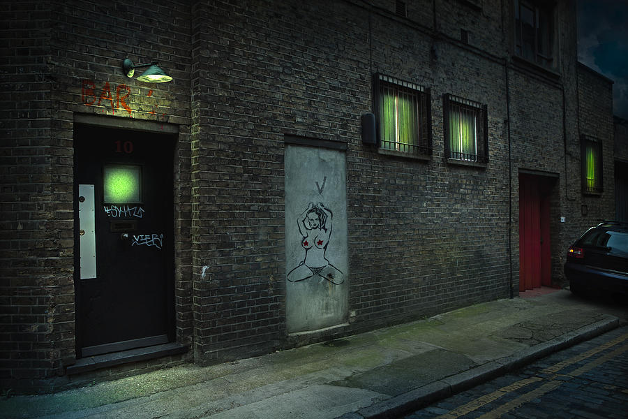 Graffiti on alley doors in city at night Photograph by Chris Clor