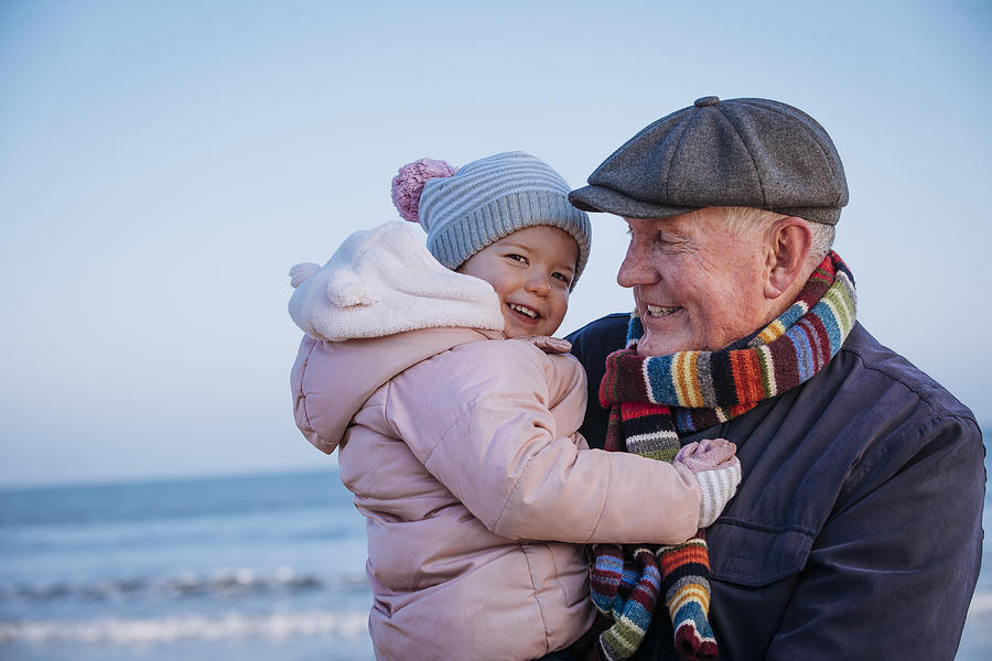 Grandfather with his Granddaughter on the Coast Photograph by SolStock