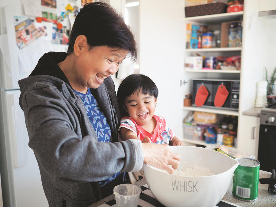 Grandma and grandson baking together Photograph by Lesley Magno