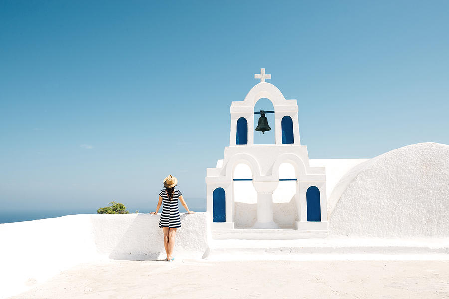 Greece, Santorini, Oia, back view of woman standing next to bell tower looking to the sea Photograph by Westend61