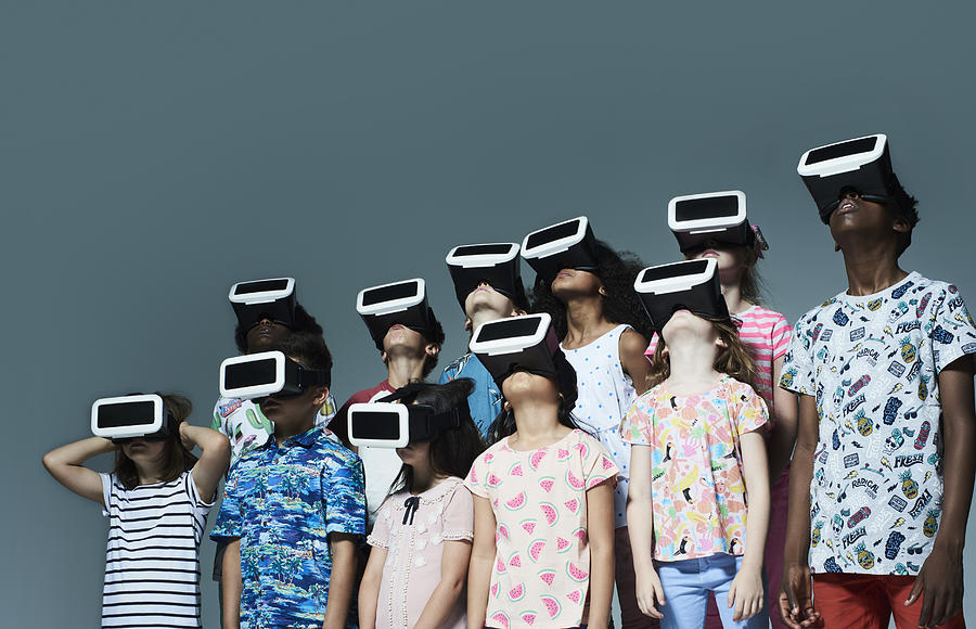 Group of children wearing virtual reality headsets Photograph by Flashpop