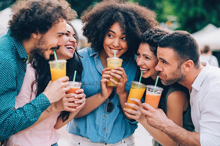 Group of friends drinking smoothies Photograph by Pixelfit